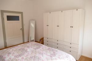 Schlafzimmer mit einem Bett, weißen Schränken und einer Tür in der Unterkunft Spatzennest in Wernigerode + 34 Fotos