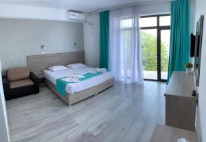 ein Schlafzimmer mit einem Bett, einem Stuhl und einem Fenster in der Unterkunft Vila Elva in Eforie Sud