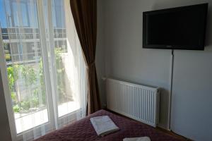 um quarto com uma televisão na parede ao lado de uma janela em Fabryka em Sopot