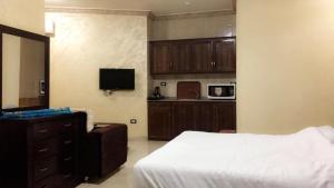 ein Schlafzimmer mit einem Bett und eine Küche mit einer Mikrowelle in der Unterkunft Al Tawheed Hotel Apartments in Amman