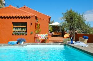 uma piscina em frente a um edifício laranja em Tres Almendros by I N Z U L A E em Vega de San Mateo