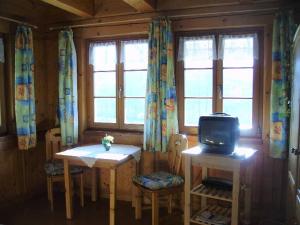 a room with two tables and a tv on a table at Am Neuhausbauernhof in Königsfeld im Schwarzwald
