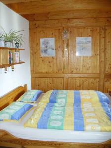 a bedroom with a bed with a blue and yellow comforter at Am Neuhausbauernhof in Königsfeld im Schwarzwald
