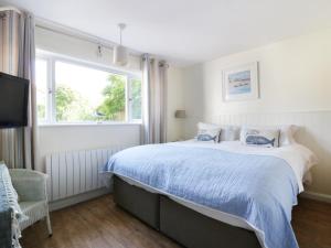 a bedroom with a large bed and a window at Keelyn in Crantock