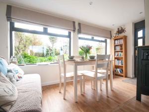 a dining room with a table and chairs and a window at Keelyn in Crantock