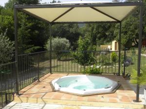 een hot tub in een prieel op een patio bij La Bergerie in Plan-de-la-Tour