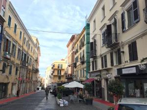 サッサリにあるDesign Apartments Sassari-Skylineの建物のある街路を歩く男