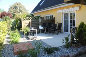 a patio with a table and chairs in a garden at Ferienwohnung Charlotte in Ostseebad Karlshagen