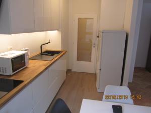 a small kitchen with a microwave and a refrigerator at ROBI in Kraljevica