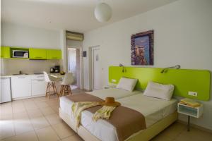 a bedroom with a large bed with a green headboard at Blue Horizon Apartments in Balíon