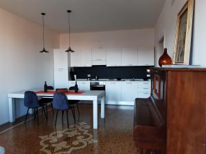 a kitchen with a table and blue chairs in it at Sunrise Apartment in Giudecca in Venice