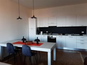 威尼斯的住宿－Sunrise Apartment in Giudecca，厨房配有白色的桌子和蓝色的椅子