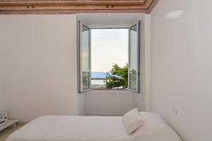 sypialnia z oknem z widokiem na ocean w obiekcie Casa del cardinale w mieście Santo Stefano al Mare