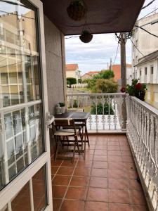 balkon ze stołem i krzesłami na balkonie w obiekcie Vivienda Cousillas w mieście Noalla