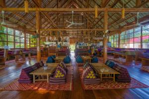 a living room filled with lots of chairs and tables at Paradise Villas Koh Rong Sanloem in Koh Rong Sanloem