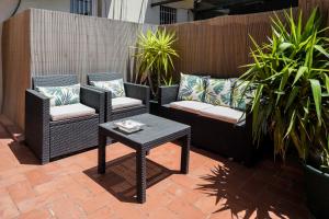 een patio met 2 rieten stoelen en een tafel bij Magic Apartment with Private Terrace in Barcelona