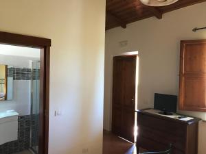 a room with a door and a desk with a computer at Hotel Belvedere in Teulada