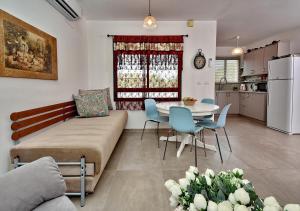 a living room with a couch and a table and chairs at Zemer Lodging in Sede Eli‘ezer