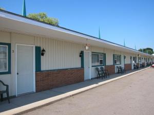 a building with tables and chairs on the side of it at Fundy Spray Motel in Middleton