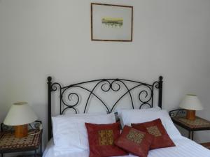 1 dormitorio con 1 cama con sábanas y almohadas blancas en Les Acanthes en Lauris