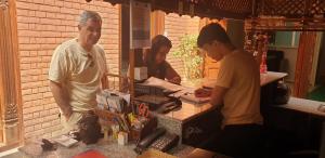 two men and a woman standing at a counter at Inn Sangrahalaya in Bhaktapur