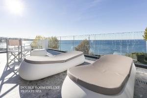a balcony with two beds and a view of the ocean at MaisonMe Boutique Hotel in Bardolino