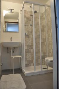 bagno con doccia, lavandino e servizi igienici di Casa Tania a Pozza di Fassa