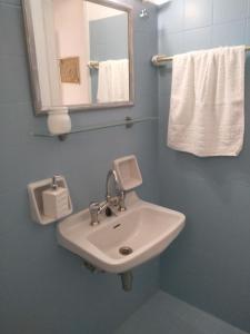 a bathroom with a sink and a mirror and towels at Galaxy Apartments in Aliki