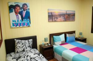 ラスパルマス・デ・グランカナリアにあるRoom in My Vintage Homeのベッドルーム1室(ベッド2台付)が備わります。壁にポスターが付いています。