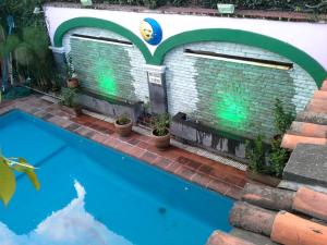 a swimming pool in front of a house with a brick wall at Villa Bonita Les Terrasses in Cuernavaca