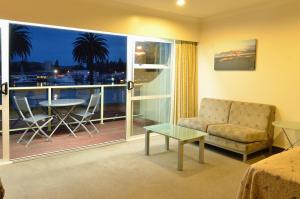 a room with a couch and a table and a balcony at Senator Motor Inn in Gisborne
