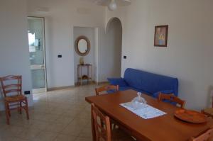 sala de estar con sofá azul y mesa en Case Vacanza La Serricella, en Santa Cesarea Terme