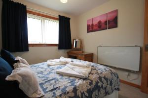 a bedroom with a bed with towels on it at An Airigh in Stornoway