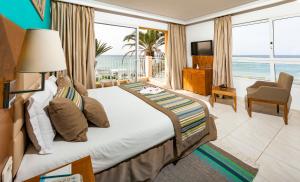 a bedroom with a bed with a view of the ocean at AQI Skanes Resort in Monastir