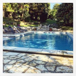 a large swimming pool with lounge chairs in a yard at Le moulin des Sens - SPA-SAUNA in Orthez