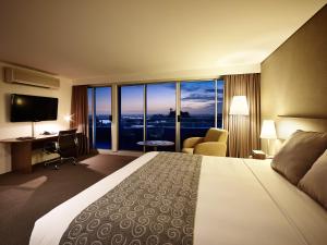 シドニーにあるホテル アーバン セント レナーズのベッド、デスク、テレビが備わるホテルルームです。