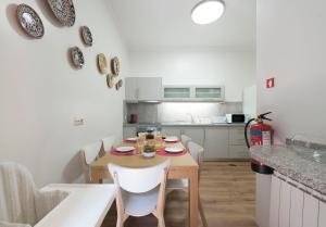 eine kleine Küche mit einem Holztisch und weißen Stühlen in der Unterkunft LovelyStay - Heritage Collection House with 4Bedrooms in Porto