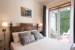 Schlafzimmer mit einem Bett und einer Glasschiebetür in der Unterkunft LovelyStay - Heritage Collection House with 4Bedrooms in Porto