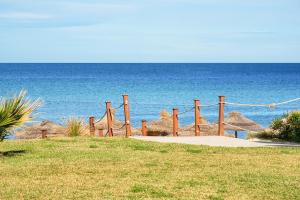 a wooden fence on the beach near the ocean at AQI Skanes Resort in Monastir