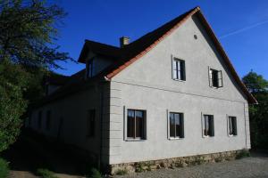Chalupa Hojna Voda في Horní Stropnice: بيت أبيض بسقف أسود