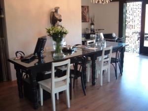 een eettafel met stoelen en een vaas met bloemen bij Groeps Villa 24 pers. in Voorthuizen