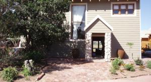 维德尼斯Stone Cottage at Pirates Creek的白色的房子,有窗户和门