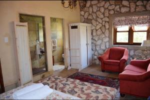 维德尼斯Stone Cottage at Pirates Creek的一间卧室配有一张床、一把椅子和石墙