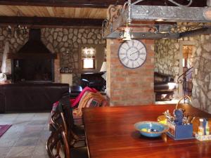维德尼斯Stone Cottage at Pirates Creek的墙上有桌子和时钟的房间