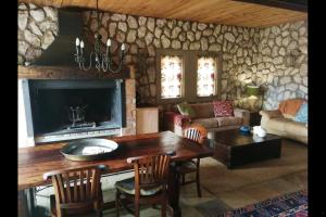 维德尼斯Stone Cottage at Pirates Creek的带桌子和壁炉的客厅