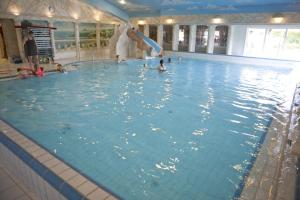 a group of people swimming in a swimming pool at Groepsboerderij 20 pers. in Voorthuizen