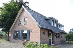 ein braunes Haus mit schwarzem Dach in der Unterkunft Groepsboerderij 20 pers. in Voorthuizen