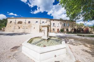 un edificio con una fontana di fronte di Le Relais Du Grand Logis a Mirabeau