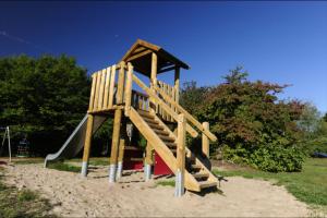 a wooden playground with a slide in the sand at Robinson Crusoe in Waldbrunn