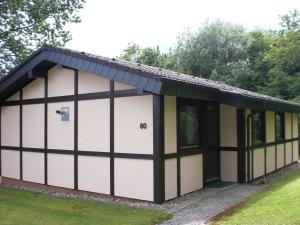 a garage with a black roof and white doors at Robinson Crusoe in Waldbrunn